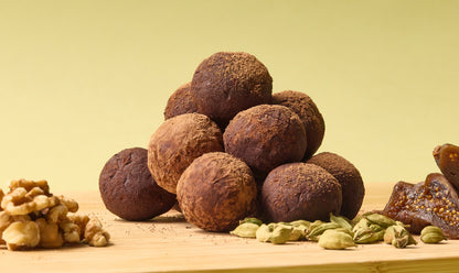 A pile of round fig and date truffles on a light background.