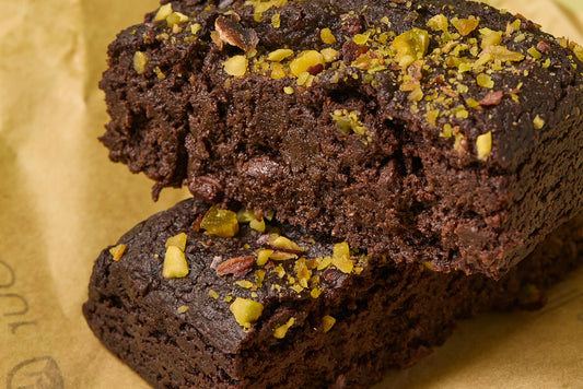A stack Beetroot brownies topped with crushed pistachio seeds