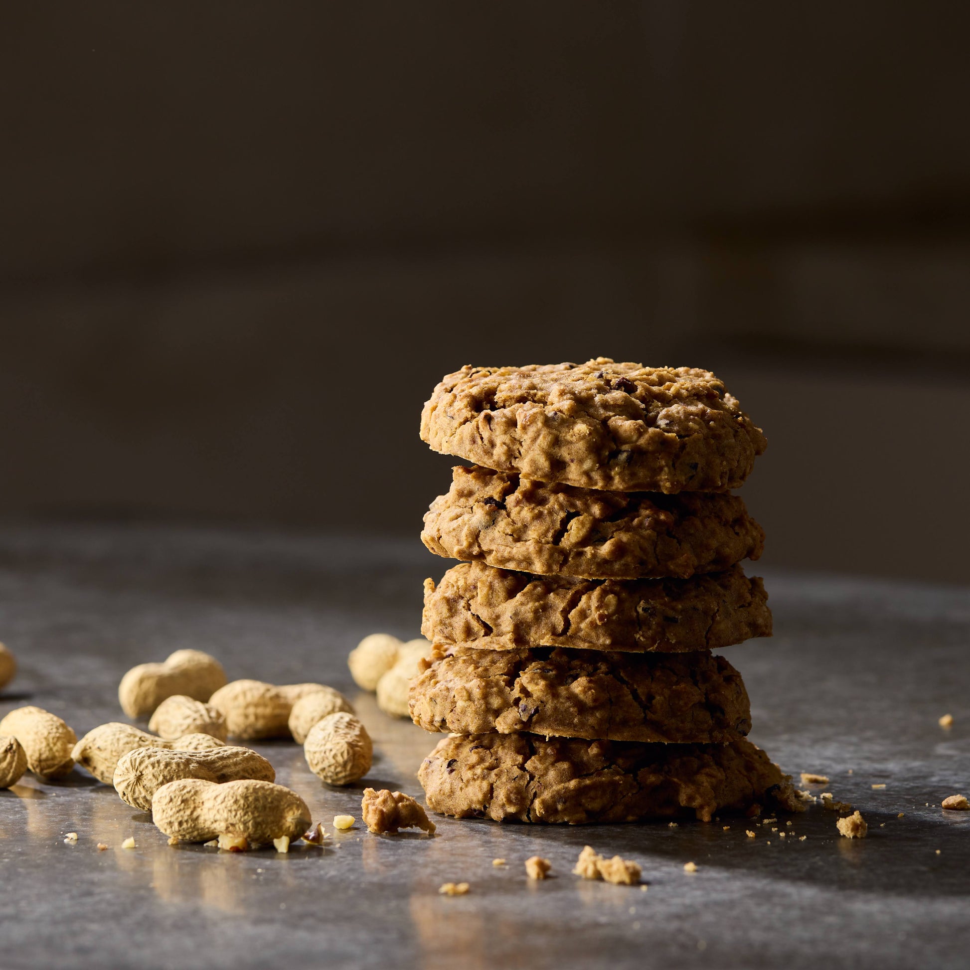 A stack of peanut butter cookies and peanut seeds